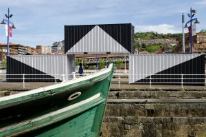 White and grey container sculpture viewed from a museum boat